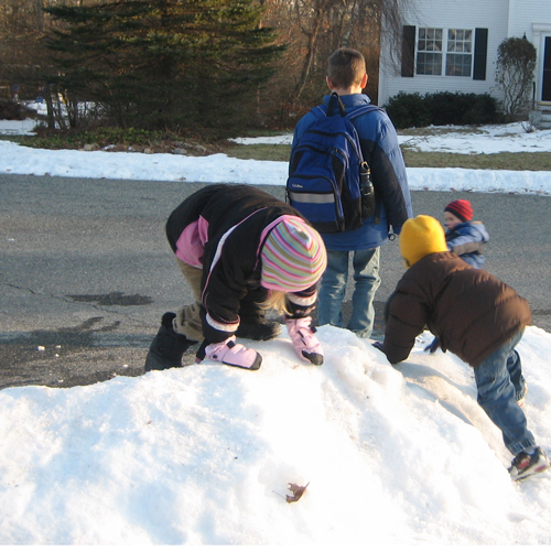Kids play in snow while waiting for bus